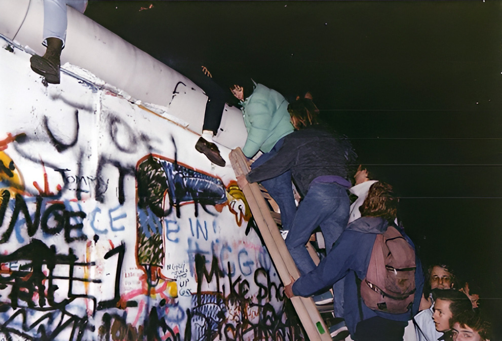 Ostberliner Bürger erklettern die Mauer